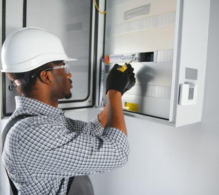 African american electrician Repairing electricity switchboard