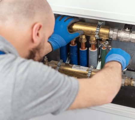 Professional plumber installing plumbing manifolds